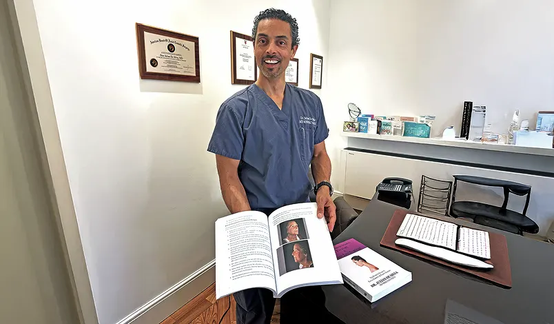 Dr De Silva with his published books on facial plastic surgery